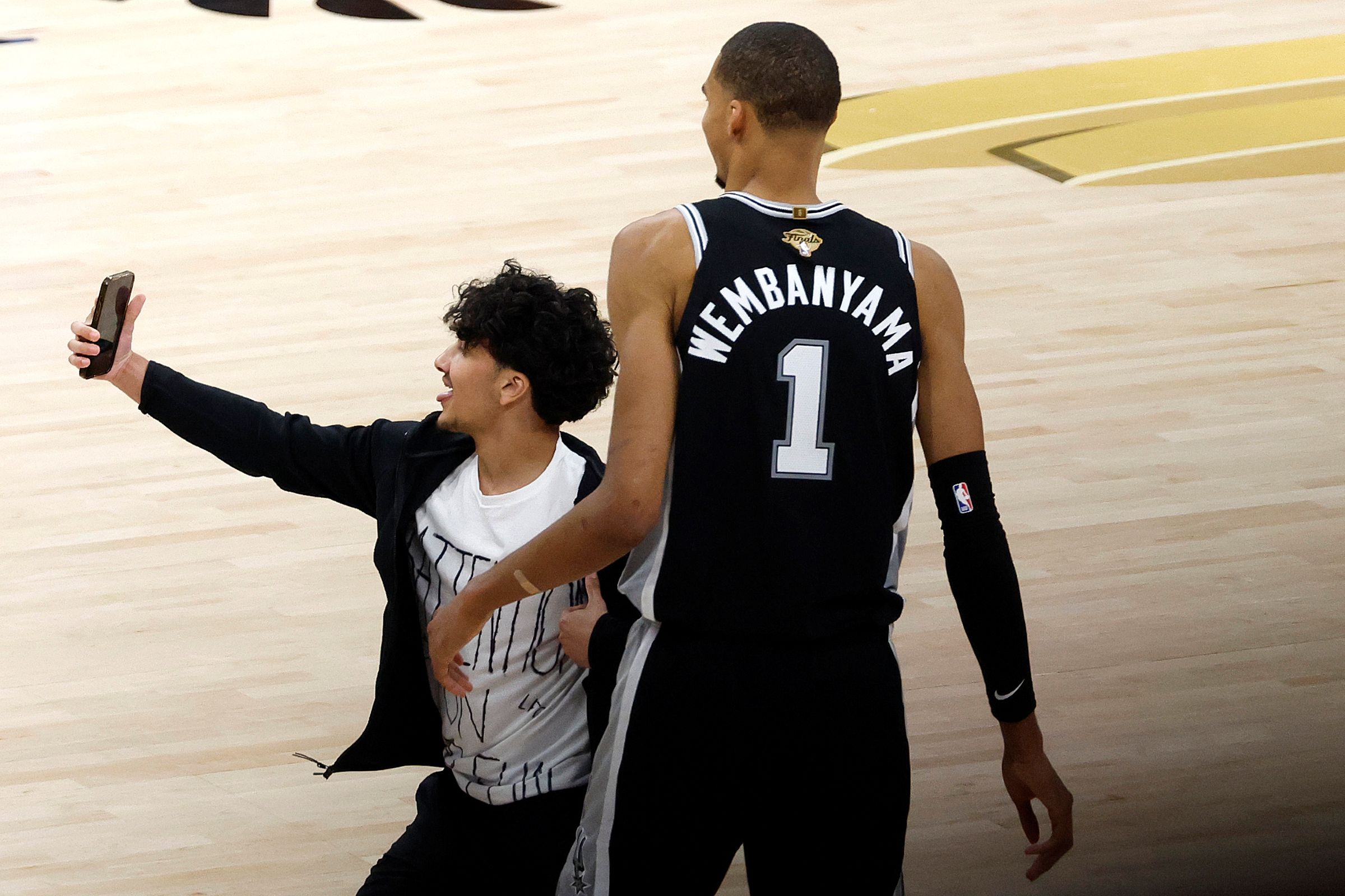 finais-da-nba:-torcedor-invade-quadra-para-tirar-foto-com-wembanyama.-confira-video