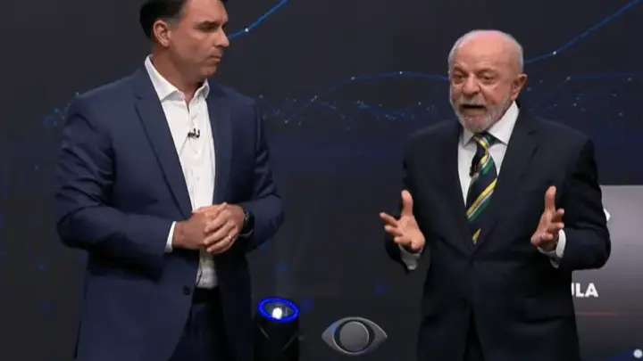 Lula fala de Covid; Flávio admite falha, mas cita “pandemia de assassinato”